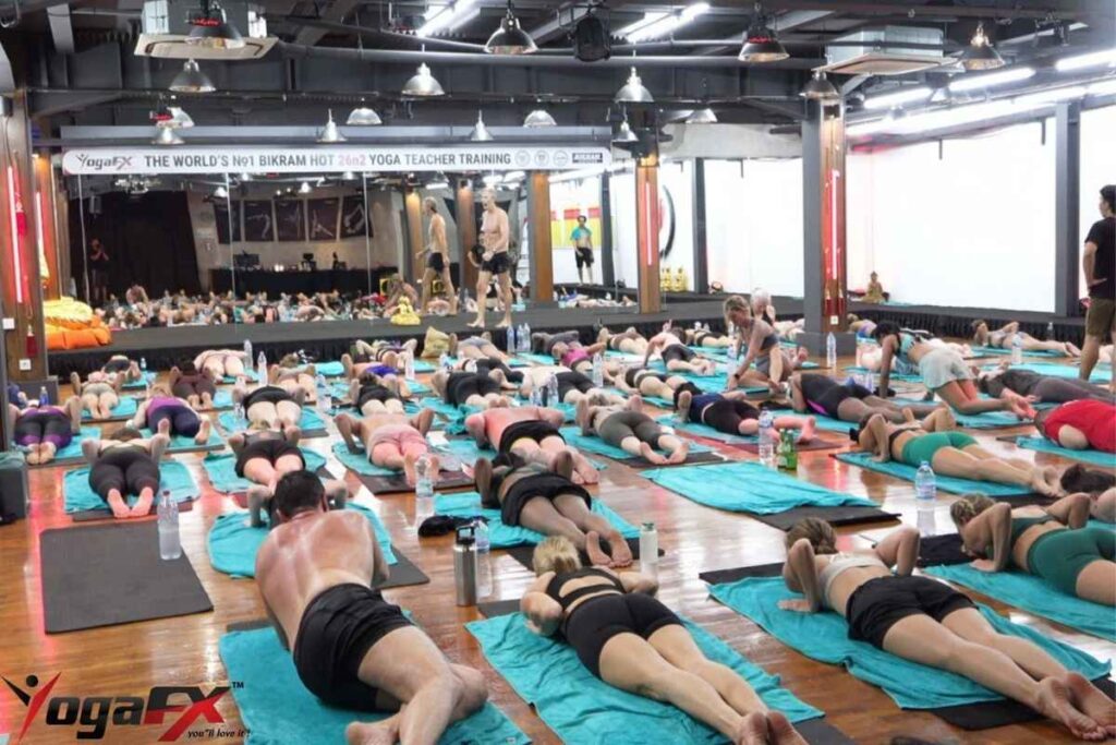 Inside the 6-Day Intensive: What YogaFX's Hybrid YTT Format Looks Like 2 YogaFX Bikram yoga teacher training candidates in a floor series and applied anatomy session on Day 3 of the intensive.