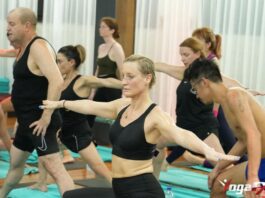 A YogaFX graduate leading a studio group class, the most common first step in a yoga teaching career after finishing the RYT 200 + Bikram Hot 26&2 certification.