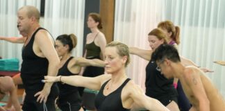 A YogaFX graduate leading a studio group class, the most common first step in a yoga teaching career after finishing the RYT 200 + Bikram Hot 26&2 certification.