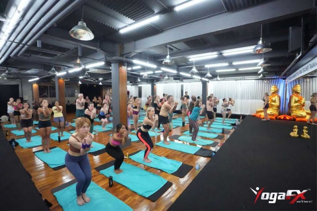 Bikram Yoga Instructor Course: Curriculum, Format & Certification 3 Bikram yoga instructor course candidate leading a supervised practice-teaching assessment in front of Ian Terry and the YogaFX cohort.