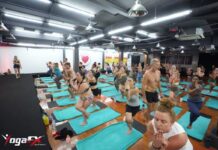 Bikram Yoga Instructor Course: Curriculum, Format & Certification Instructor course candidates practicing standing series posture clinic and alignment cues during YogaFX Bikram yoga instructor training in Seminyak, Bali.