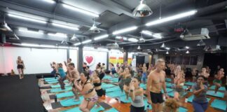 Instructor course candidates practicing standing series posture clinic and alignment cues during YogaFX Bikram yoga instructor training in Seminyak, Bali.