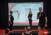 Hot Yoga Benefits for Men: What Male Trainees Notice in Bali Mr Ian Terry teaching the Half Moon Pose dialogue from a projected script while a trainee demonstrates the posture