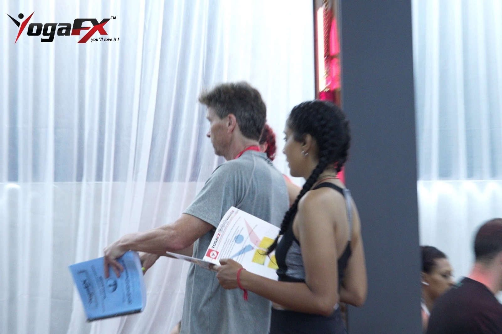 Mr Ian Terry handing course materials to a trainee during the YogaFX Hot 26 and 2 teacher training in Bali