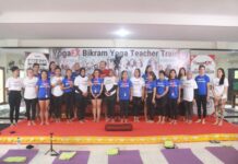 How Many Men Do Yoga? The Rise of Men in the Hot Room Report A YogaFX teacher training intake photographed together on stage beneath the Bikram Hot 26 and 2 banner in Bali